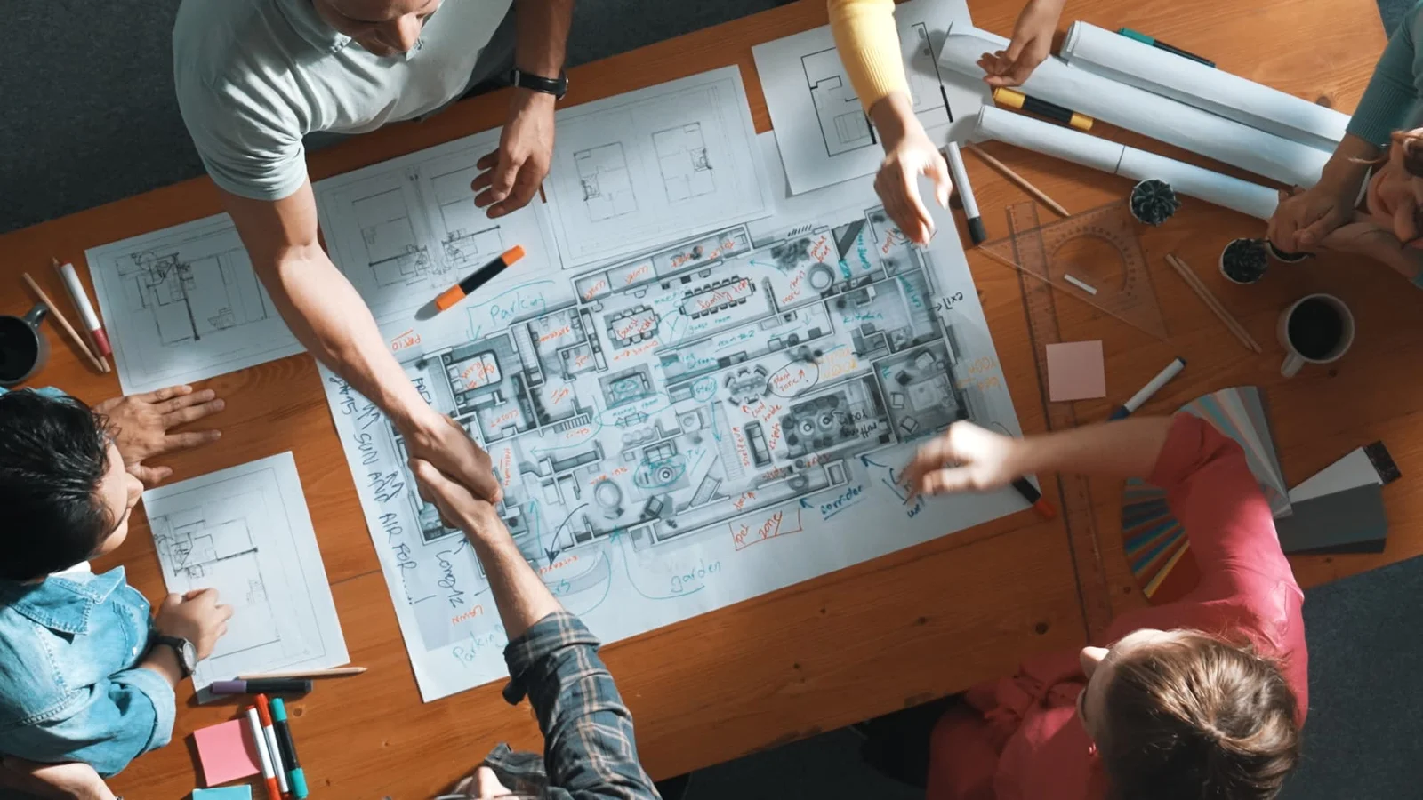 Team reviewing architectural plans and drawings around a table